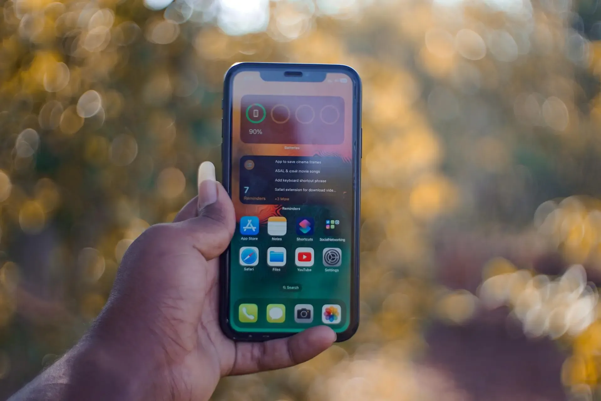 Man holding iphone displaying widgets on screen