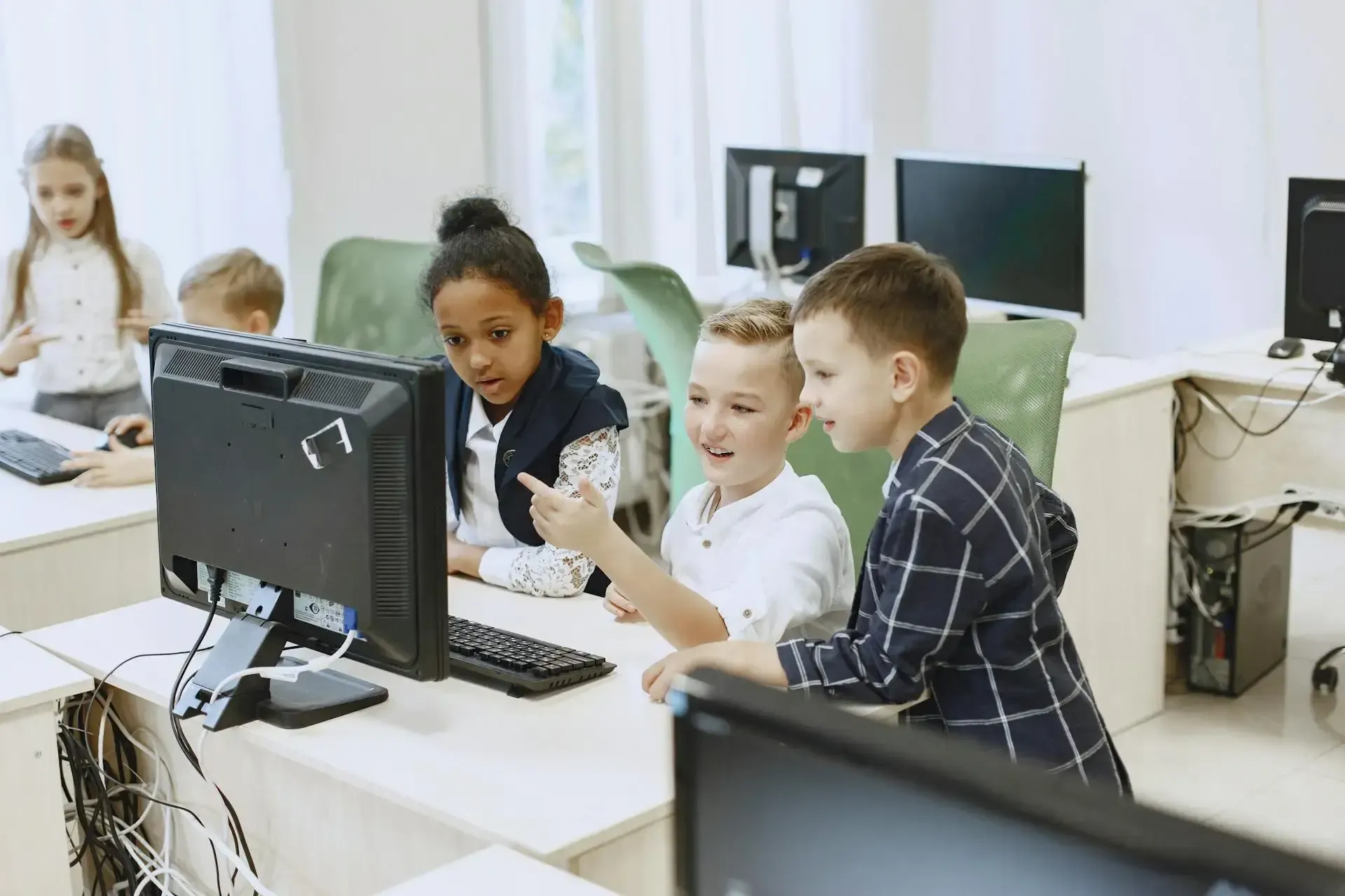 Pupils all on computers laughing and enjoying websites