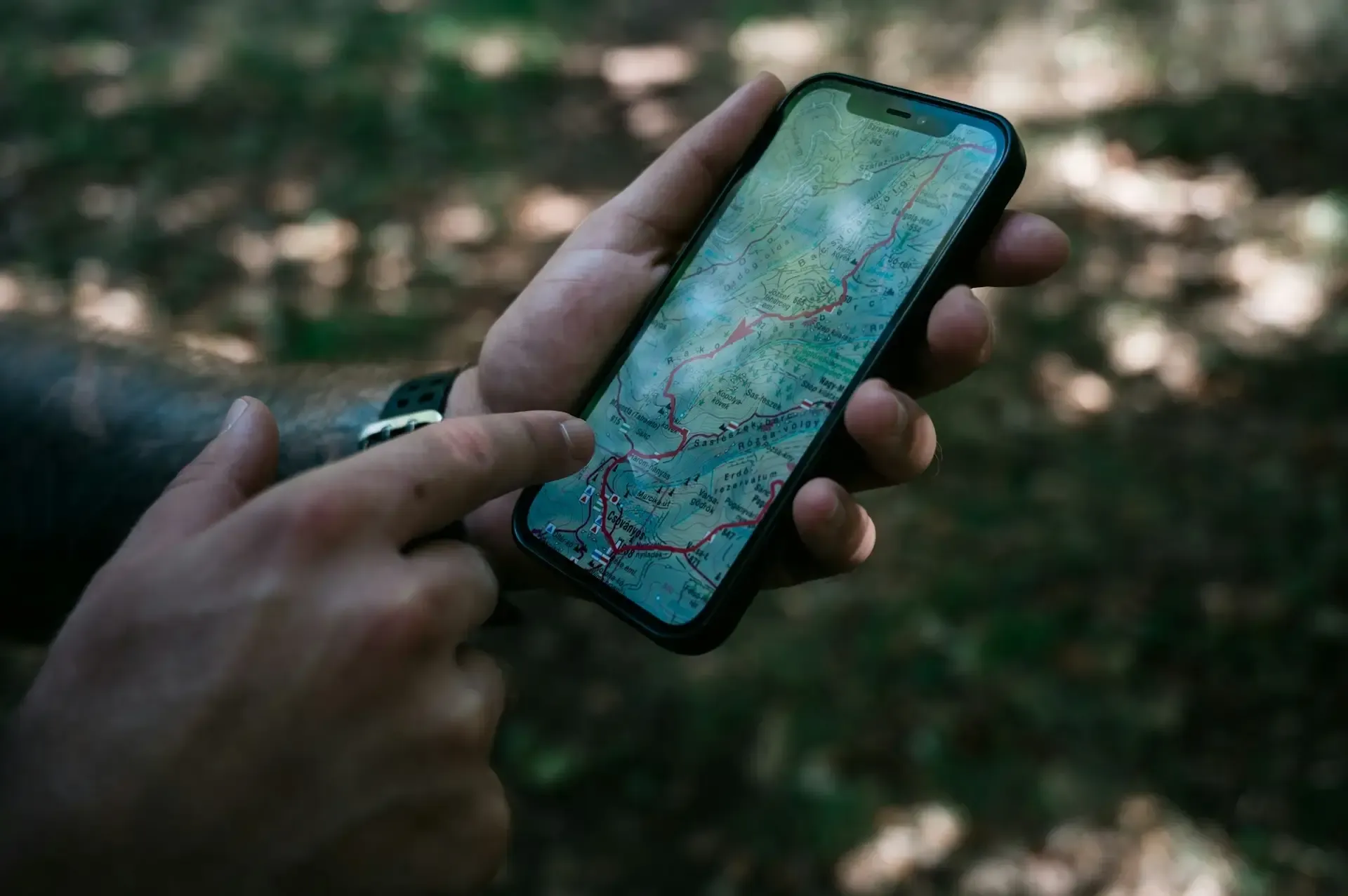 Man pointing at tracking map on mobile phone