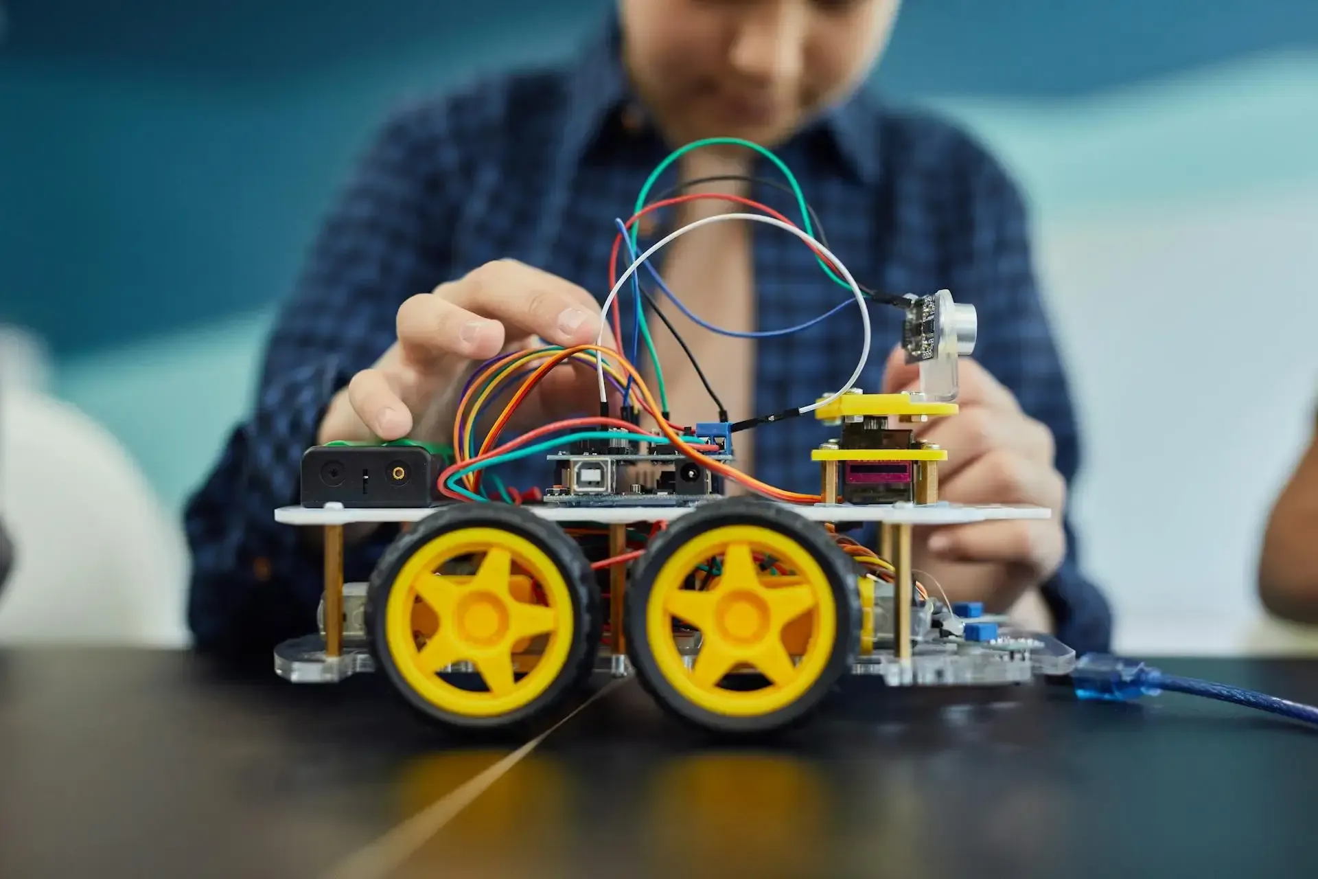 Young boy building robot car